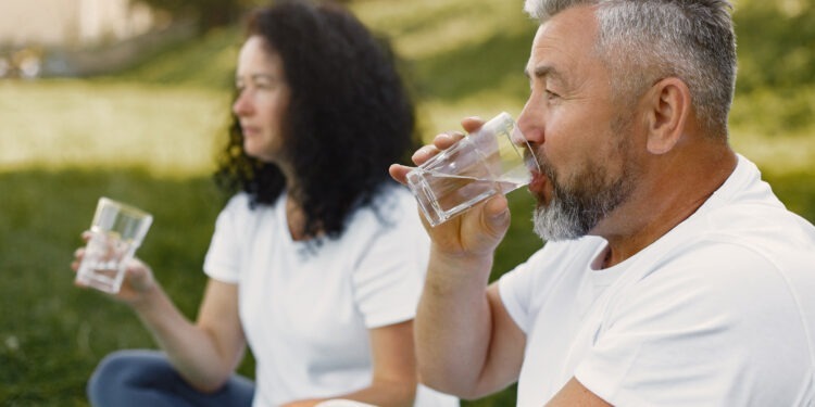 Discover the '15 Signs You Are Not Drinking Enough Water' with our insightful guide. Learn about common and lesser-known symptoms of dehydration, the importance of staying hydrated, and practical tips to ensure adequate water intake. Ideal for those seeking to improve their health and wellness. This article is a must-read for anyone looking to Couple enjoying a refreshing drink of water outdoors, embodying the benefits of hydration. 15 signs you are not drinking enough water