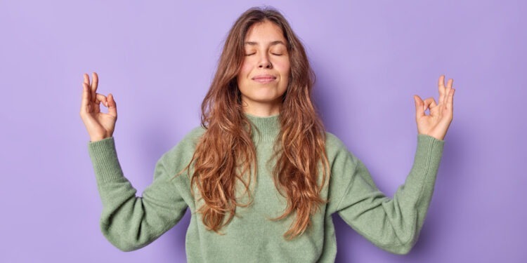 Anxiety reducing techniques- Woman practicing Zen meditation with Om gesture, symbolizing peace and mindfulness, isolated on a purple background