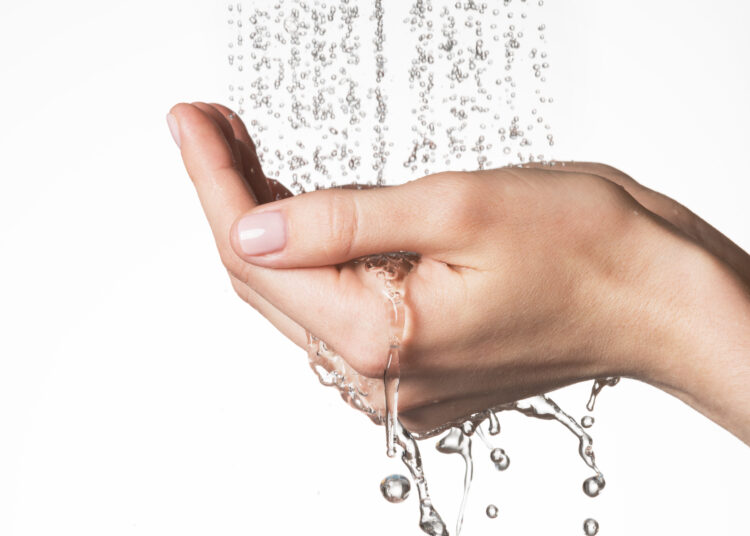 Close-up of female hands under water, symbolizing the rejuvenating effect in '10 benefits of cold showers