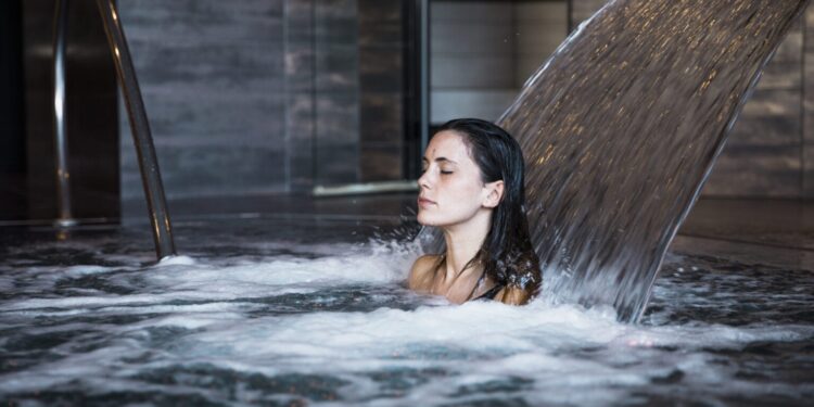 10 benefits of cold showers - Woman experiencing the benefits of cold water therapy in a natural pool