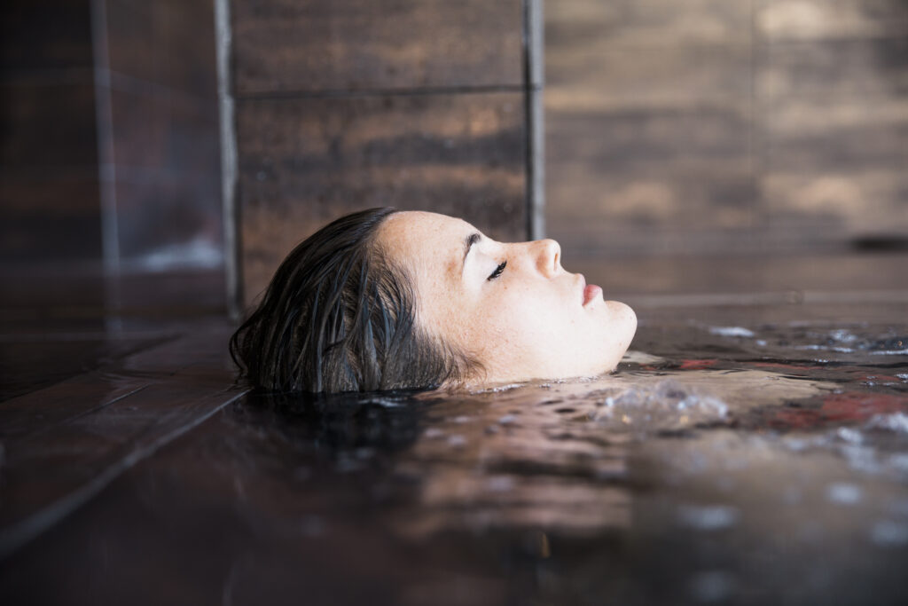 Woman relaxing in a serene cold plunge pool setting