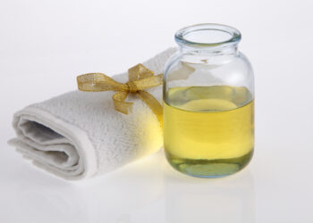 castor oil bottle and towel on white background