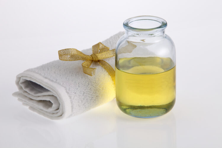 castor oil bottle and towel on white background