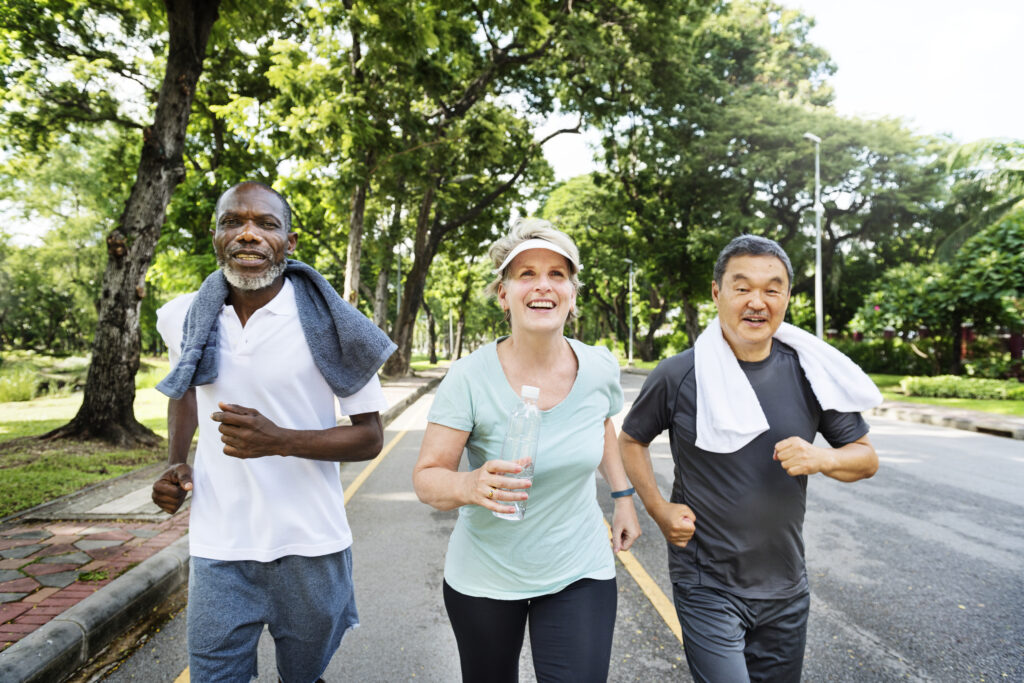 Group of senior friends jogging together in a park, embodying pillars of health